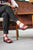 woman, sitting in library, reading book, wearing black pants and burgundy New Mexican handmade leather shoes by Aurora Shoe Co.