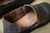 Top down angle of Men's Middle English Handmade Leather shoes in aged olive color, peering down into Horween Latigo midsole, on wood floor