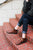 Woman sitting on brick steps wearing brown handmade leather shoes by Aurora Shoe Co.