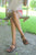 woman sitting on swing, wearing brown handmade leather New Mexican sandals by Aurora Shoe Co.