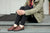 Woman sitting on steps in front of Aurora Inn wearing brown Middle English handmade Leather Shoes.