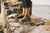 Model standing on stone wall with Cayuga Lake in background, wearing Middle English Olive Handmade Leather Shoes by Aurora Shoe Co.